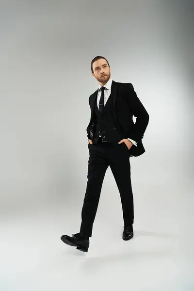 Bearded businessman exudes confidence in stylish suit and tie against a neutral background. — Stock Photo