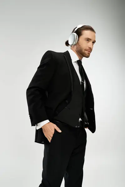 A bearded businessman in a suit wears headphones, lost in the music playing in his ears. — Stock Photo