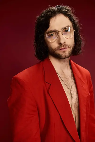 Красивий чоловік у червоному костюмі впевнено позує без сорочки, виключаючи відчуття стилю та вишуканості. — стокове фото