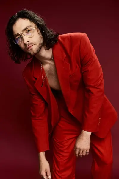 A handsome man in a striking red suit and glasses poses confidently, exuding style and sophistication. — Stock Photo