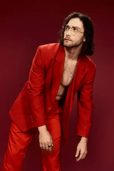 Handsome man in red suit striking pose without shirt in a studio setting. — Stock Photo