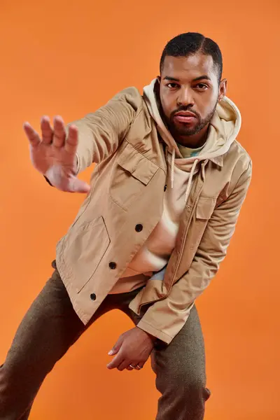 A stylish African American man posing against a vibrant backdrop. — Stock Photo