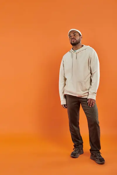 African American man posing against a bright orange background. — Stock Photo