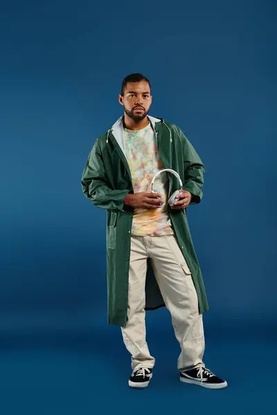 Confident man strikes a pose against a vivid blue background. — Stock Photo