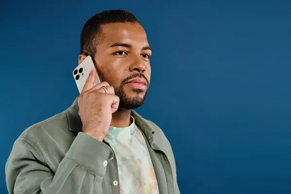 Stilvoller Mann hält Handy ans Ohr vor vibrierender Kulisse. — Stockfoto