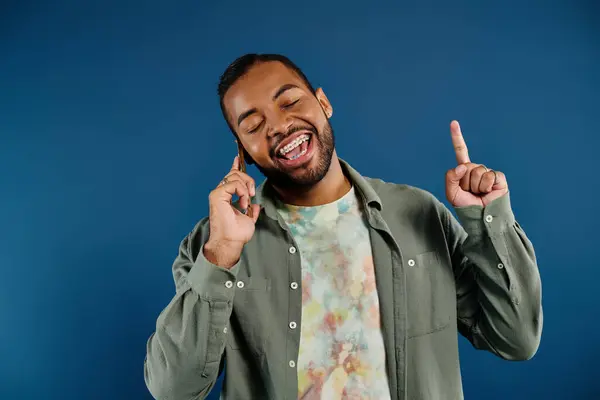 Stylish African American man holding cell phone to ear on vibrant backdrop. — Stock Photo