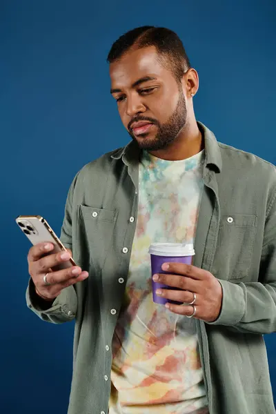 Elegante uomo telefono di navigazione sorseggiando caffè. — Foto stock