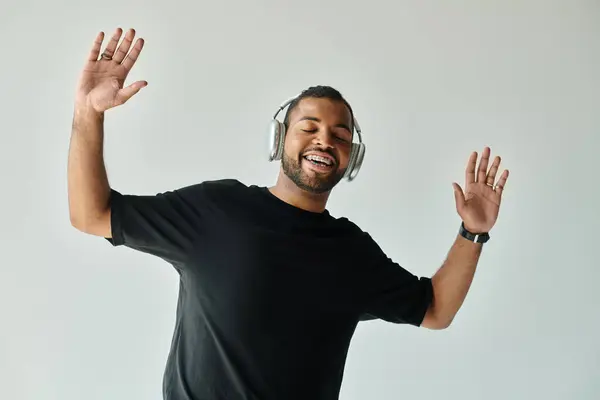 African American man in black shirt listening to headphones. — Stock Photo