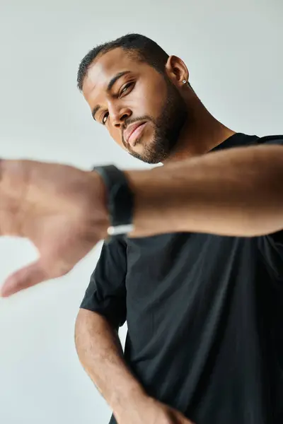 Un uomo afroamericano alla moda che punta verso qualcosa con la mano. — Foto stock