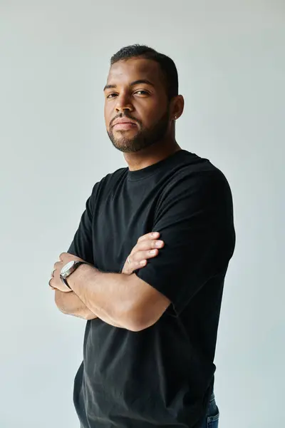 Stylish African American man confidently stands with arms crossed. — Stock Photo