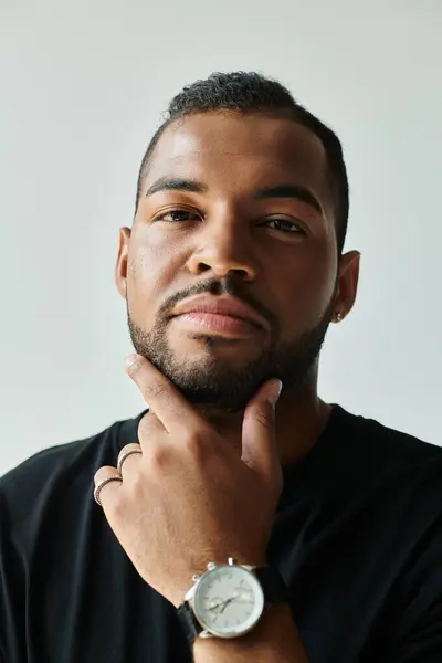 Stylish African American man showcasing a watch on his wrist against a vibrant backdrop. — Stock Photo