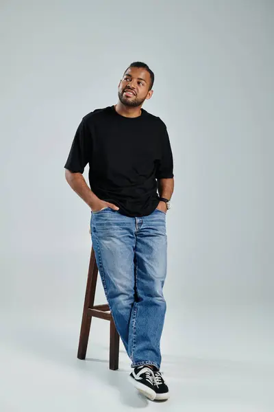 Stylish African American man standing on stool with hands in pockets. — Stock Photo