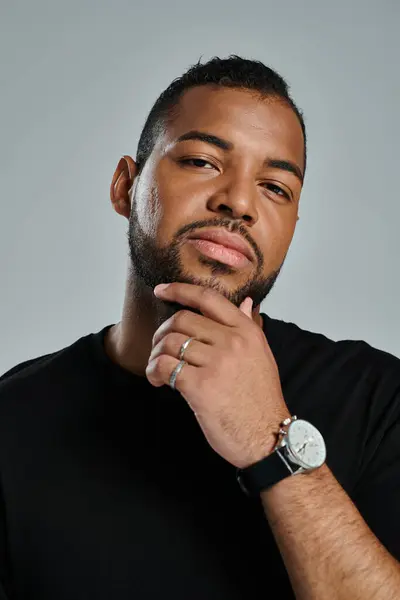 Stylish African American man showcasing wristwatch on vibrant backdrop. — Stock Photo