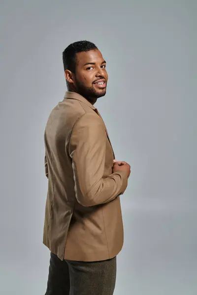 Stylish African American man posing against vibrant backdrop. — Stock Photo