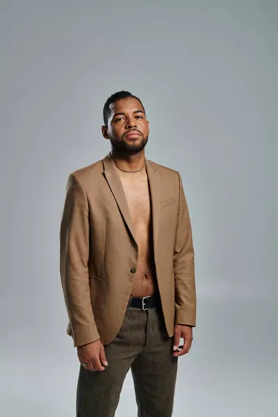 Stylish African American man posing against vibrant backdrop. — Stock Photo