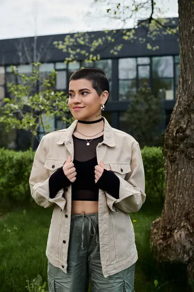 Uma jovem mulher fica graciosamente na frente de uma árvore imponente, conectando-se com a natureza. — Fotografia de Stock