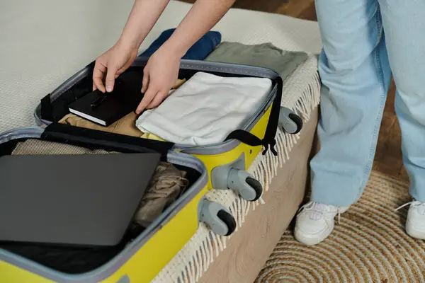 A young woman prepares for a vacation, standing over a chic yellow and gray suitcase. — Stock Photo