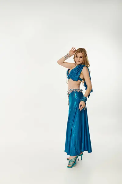 Graceful woman in a blue dress striking a pose. — Stock Photo
