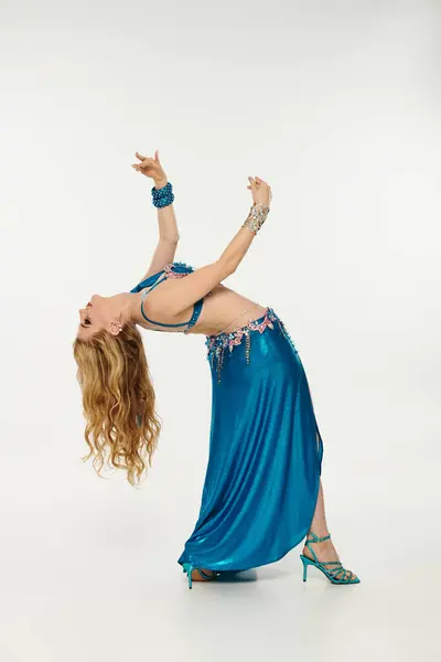 Une femme envoûtante dans une robe bleue danse gracieusement. — Photo de stock