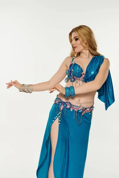 Jovem mulher em hipnotizante azul dança do ventre traje realizando movimentos expressivos. — Fotografia de Stock