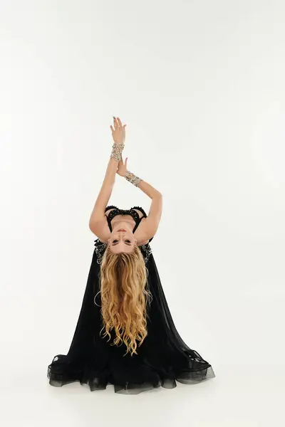 Woman in black dress effortlessly handstands — Stock Photo