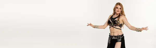 Young woman showcasing mesmerizing belly dance moves in vibrant costume. — Stock Photo