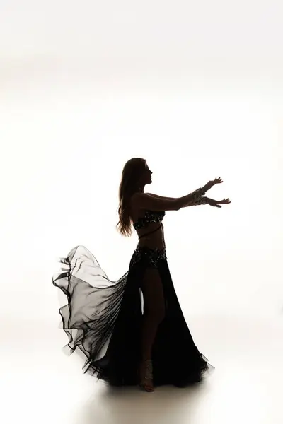 Une femme envoûtante dans une robe noire danse gracieusement. — Photo de stock