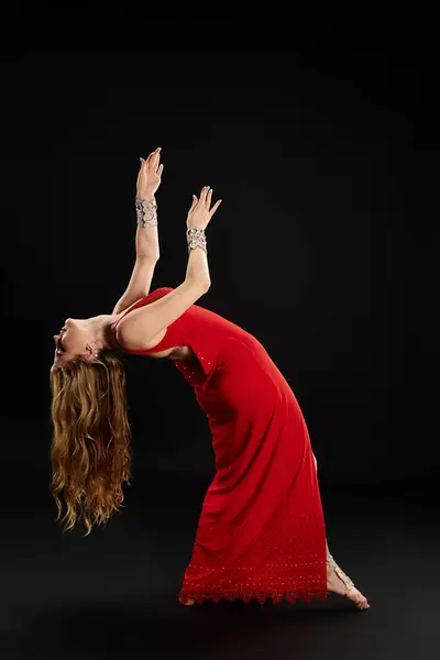 Woman in red dress executes handstand with elegance and skill. — Stock Photo