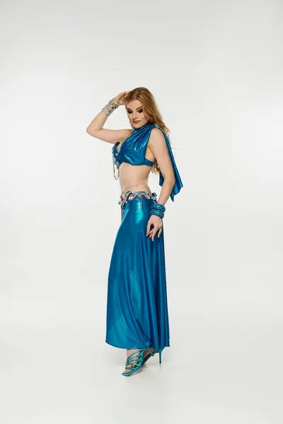 Anmutige Frau in blauem Kleid posiert elegant für ein Foto. — Stockfoto
