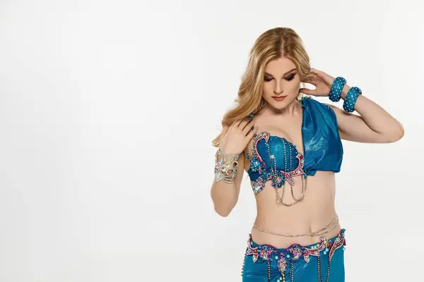 Woman in stunning blue belly dance attire showcasing graceful moves. — Stock Photo