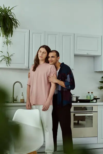 Gay couple in casual attire smiling together in a cozy kitchen. — Stock Photo