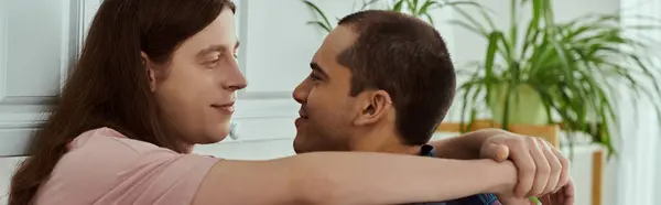 Gay couple hug each other with tenderness, expressing love and affection in a cozy home setting. — Stock Photo