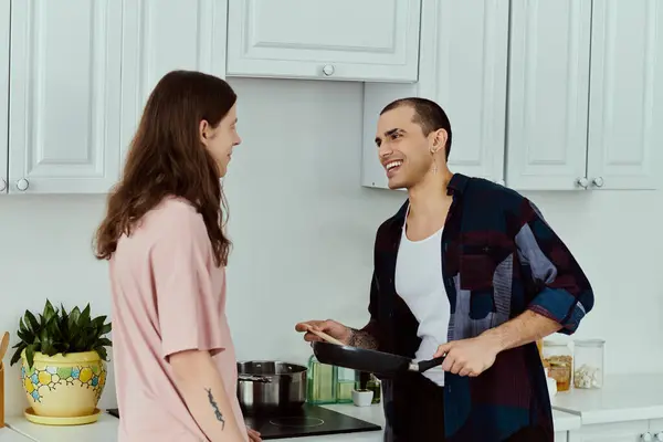 Couple in a cozy kitchen, preparing a meal together with love and laughter. — Stock Photo