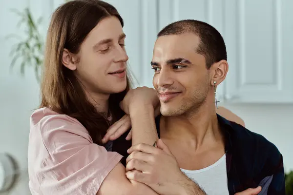 A man in casual clothes lovingly holds a partner in his arms in a tender and intimate moment at home. — Stock Photo