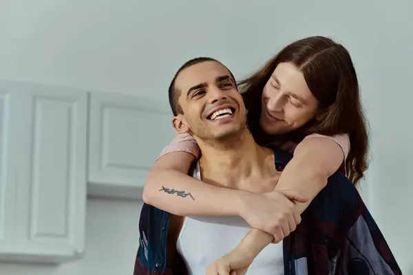A man in casual clothes holds a partner in his arms tenderly, sharing an intimate moment of love and connection. — Stock Photo