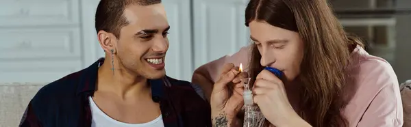 Ein schwules Paar, lässig gekleidet, zu Hause fröhlich zusammen lachend, zündet Marihuana in der gläsernen Bong an — Stockfoto