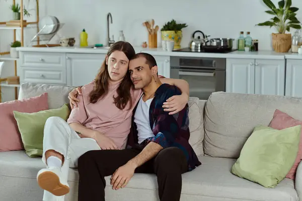 Lgbtq couple enjoy a cozy moment on a couch, laughter filling the room as they relax together. — Stock Photo