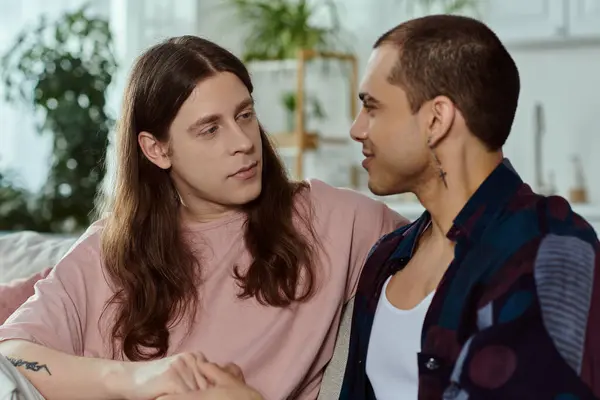 Ein schwules Paar in lässiger Kleidung lümmelt gemütlich auf einer Couch und genießt die schöne Zeit zu Hause. — Stockfoto