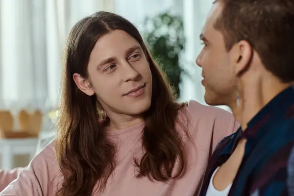 A gay couple in casual clothes stand together, engrossed in conversation. — Stock Photo