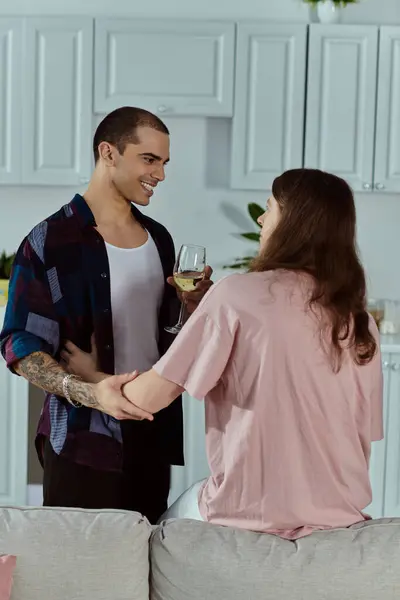 Una coppia gay, stare nel loro soggiorno con bicchieri di vino che mostrano amore, rispetto e unità. — Foto stock