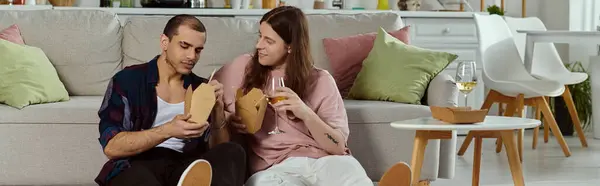 A gay couple, in casual attire, relaxing on a couch in a cozy setting, enjoying quality time together. — Stock Photo