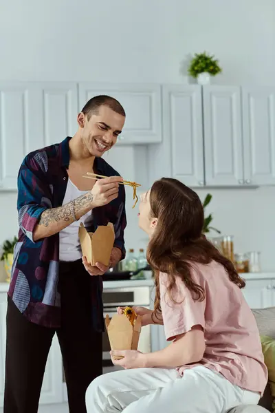 Un couple gay, profiter joyeusement d'un repas dans une cuisine confortable, partager le rire et l'amour. — Photo de stock