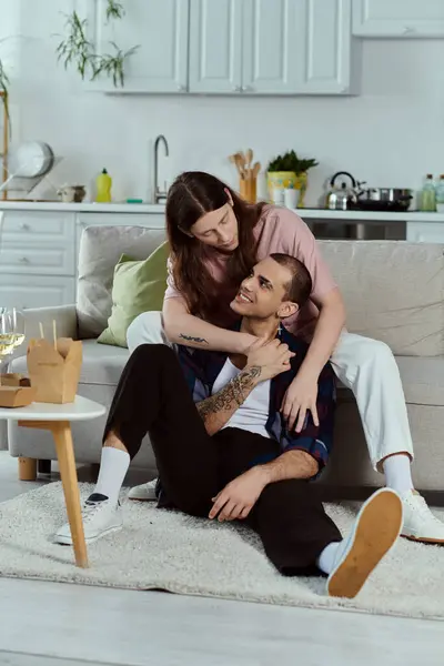 Una coppia gay vestita con disinvoltura, godendo di un momento accogliente insieme seduti su un comodo divano. — Foto stock