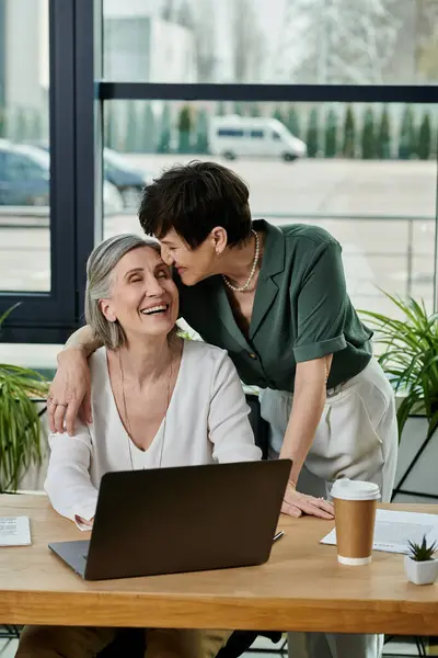 Two women by laptop in office. — Stock Photo