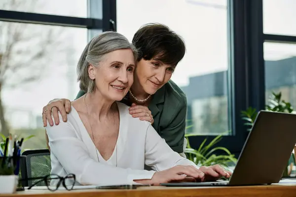 Two women engrossed in a laptops screen. — Stock Photo