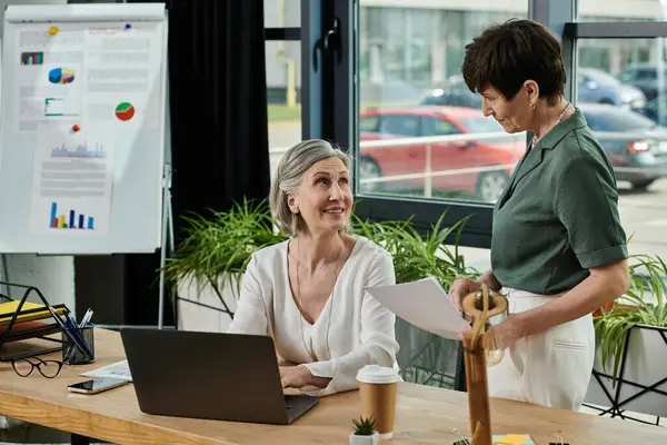 Duas mulheres na mesa, focadas na tela do laptop. — Fotografia de Stock