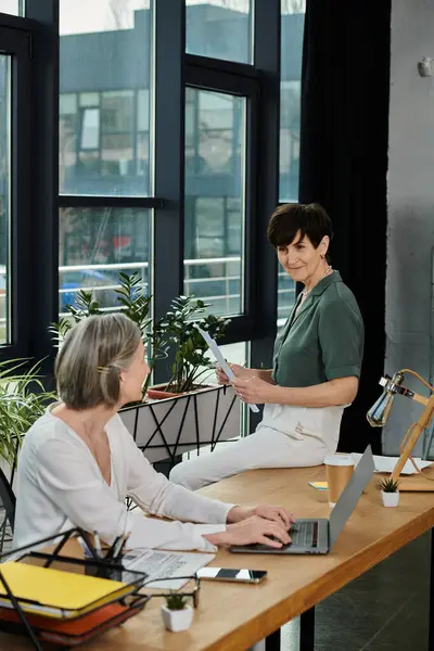 Two women at desk, focused on work. — Stock Photo