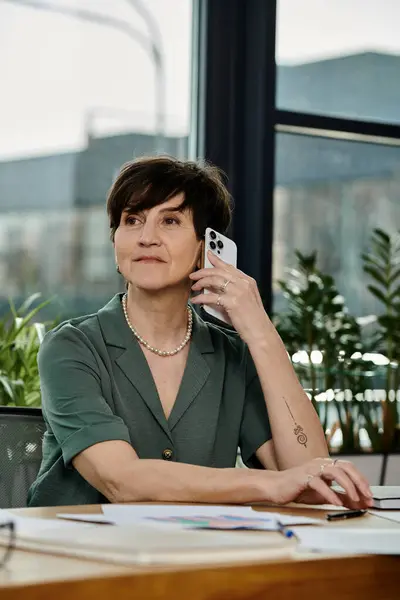 Donna alla scrivania, che parla al cellulare. — Foto stock