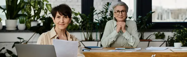 Two women work on laptops at a table in a cozy setting. — Stock Photo