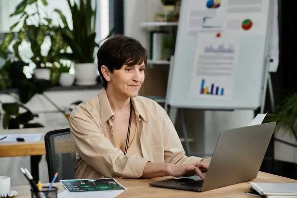 A woman sitting in front of a laptop computer, working attentively. — Stock Photo
